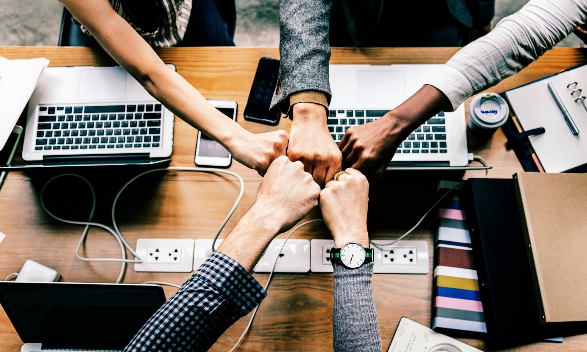 Photo by rawpixel.com from Pexels team fistbumping each other