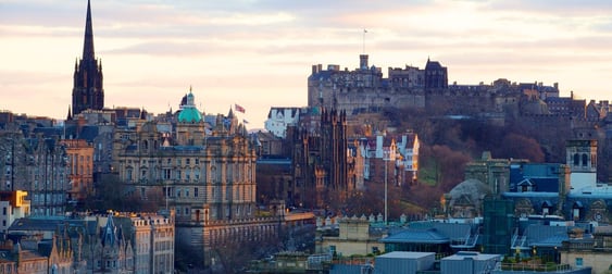 edinburgh scotland view of edinburgh castle and many old buildings trees at sunset blue orange sky