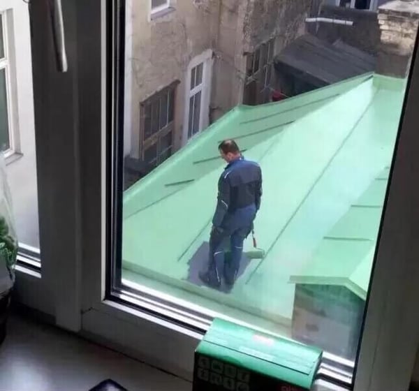 man painting roof