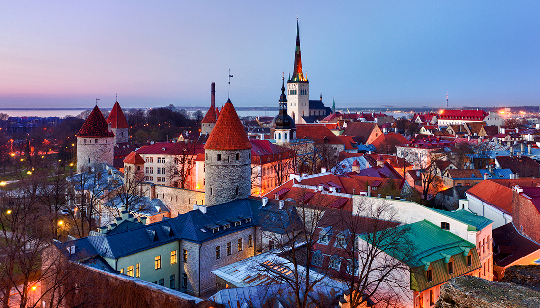 tallinn estonia white buildings red roofs sunset purple blue sky baltic sea trees