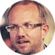 man talking, blond hair, short beard, glasses,