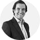 man standing, short brown hair, white shirt, black suite, smiling, black and white picture