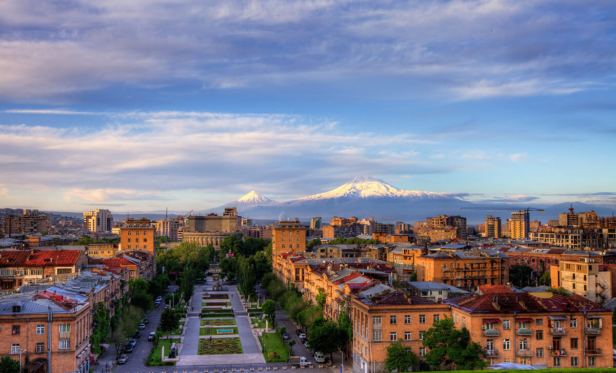 yerevan armenia green park orange buildings blue sky white clouds mountain with snow