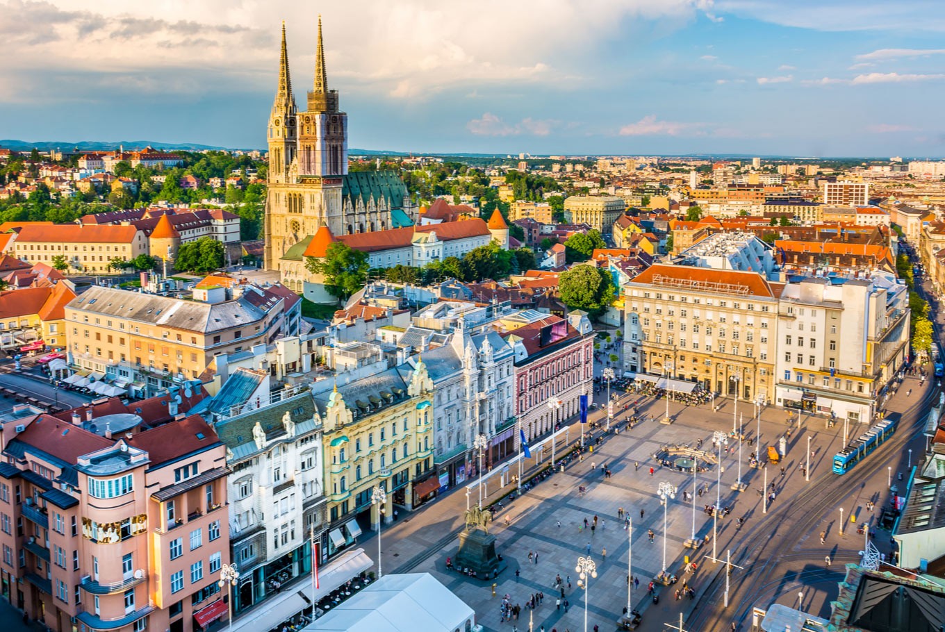 zagreb croatia town square church buildings trees apartments street lamps sky
