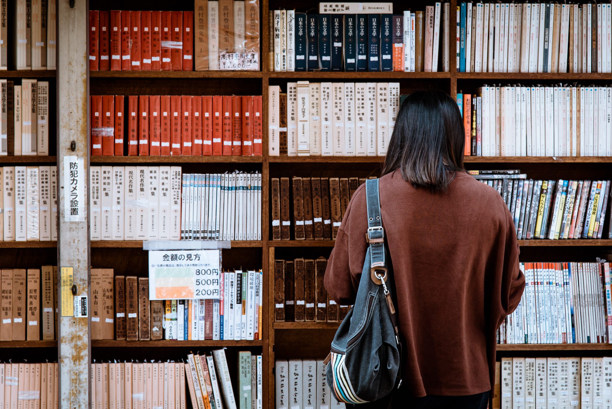 Person facing bookshelf with Japanese books