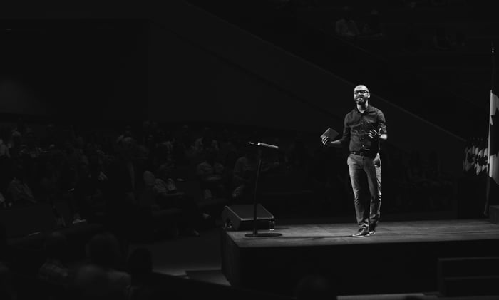 guy giving presentation on stage black and white