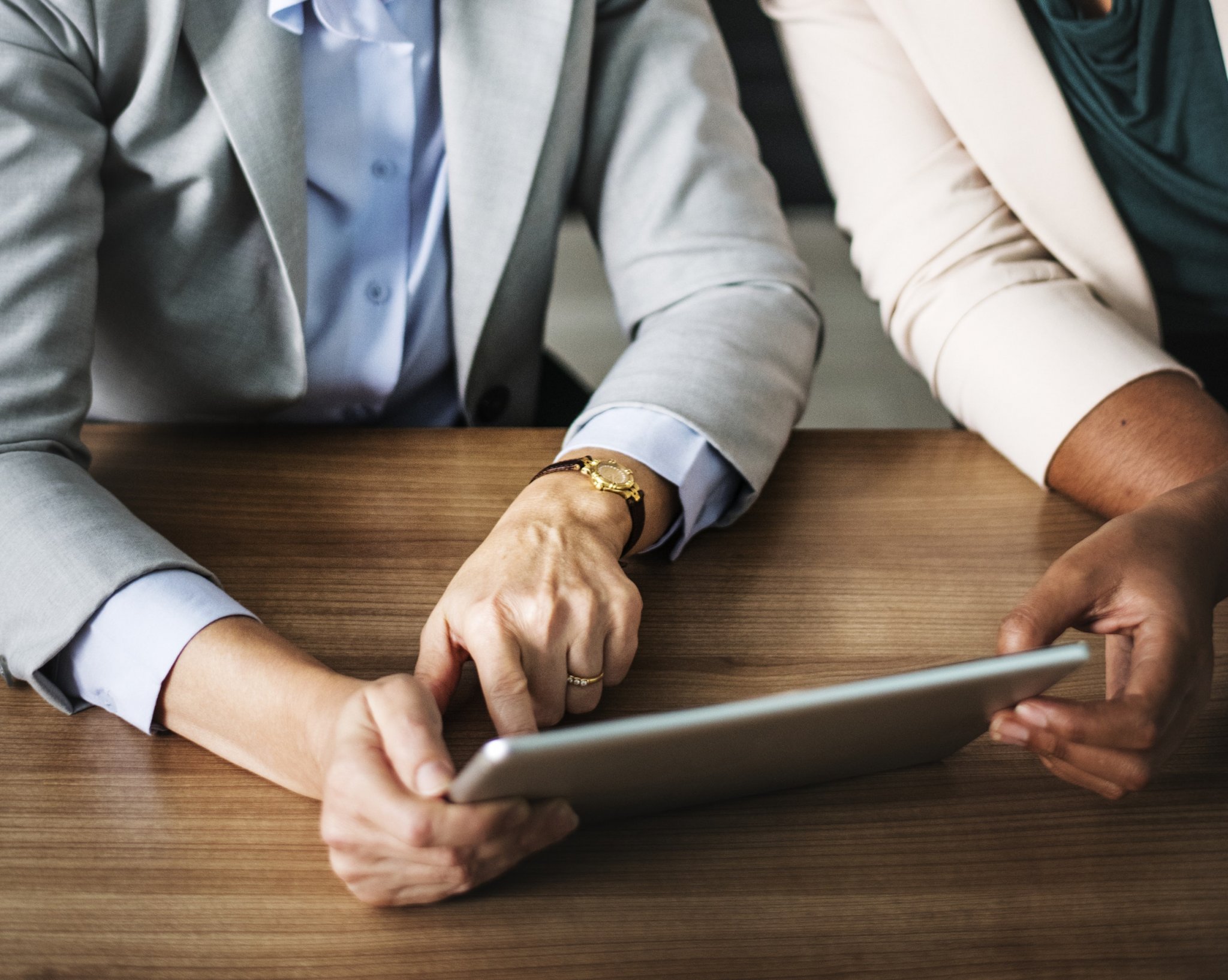 two people in suits with a tablet