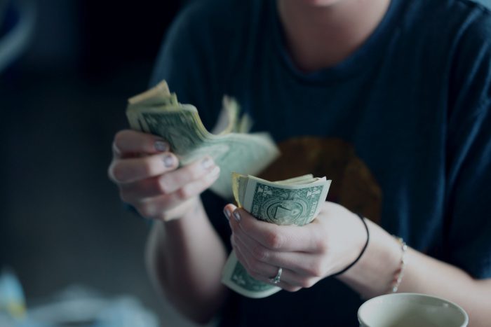 Investment, girl counts money with hands