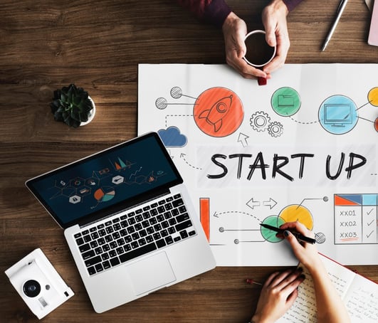 Start-up planning on a plakat and with digital devices