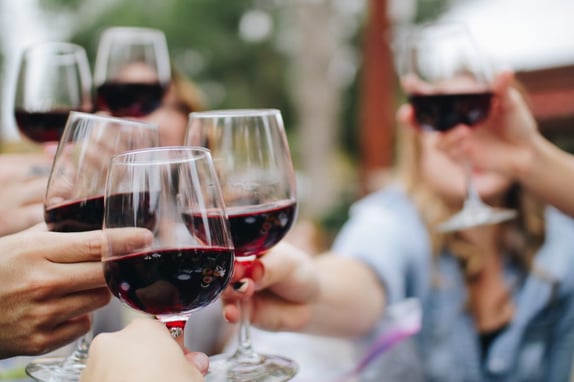People celebrating with a glass of red wine