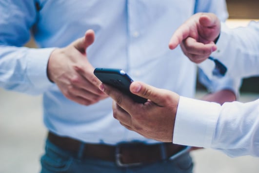 Men point on the phone screen