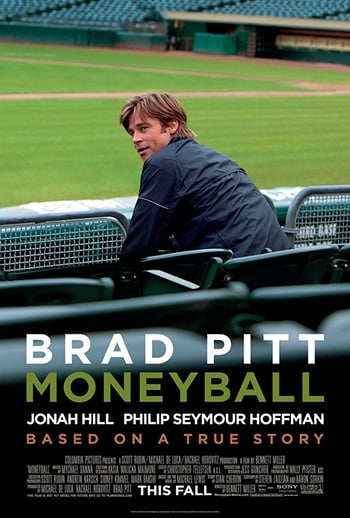 Pôster do filme Moneyball - homem vestindo jaqueta preta sentado de costas para a câmera, olhando para a câmera, em um campo de esportes, texto branco sobreposto