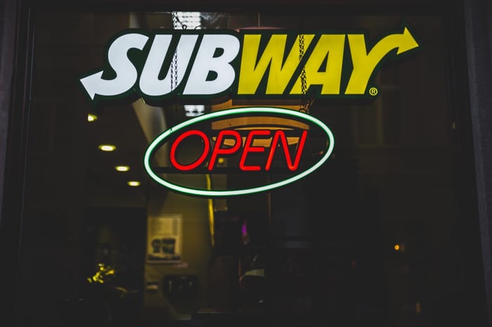 subway neon sign in white yellow and ted