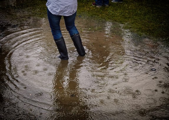 Woman in boots standing in a pond