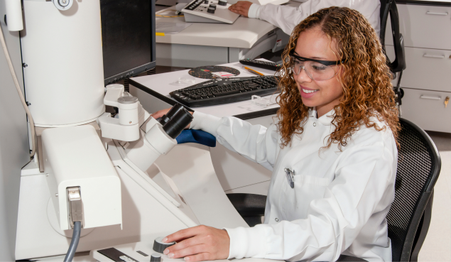 A woman in a laboratory, using microscope